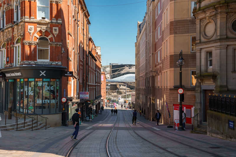 Image of a street in Birmingham showing shops and tram tracks